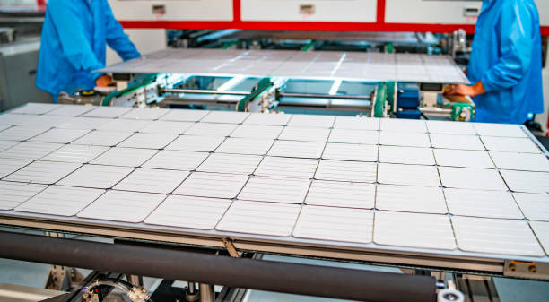 production of solar panels, men working in factory. production of solar panels, men working in factory. Closeup of heavy machinery at solar production panels factory. Industrial technic at plant. Green energy concept. solar panel manufacturing stock pictures, royalty-free photos & images