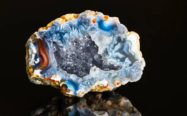 Photo of Beautiful hollow agate semi precious stone with clear raw crystals inside geode. Mineralogy