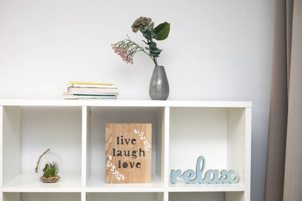 istock Stylish bookshelf with decorations for home on a white wall 1199745844