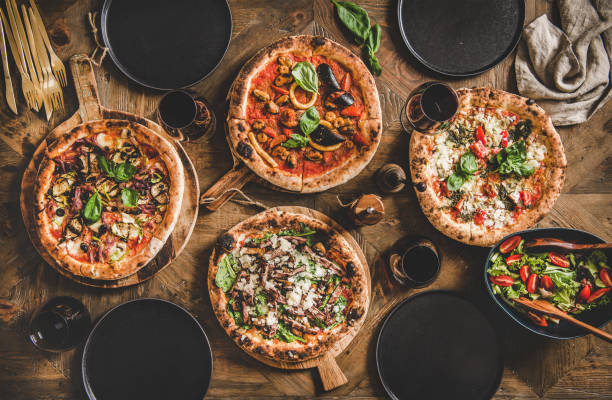 various kinds of italian pizza, fresh salad and red wine - close up directly above holiday nobody imagens e fotografias de stock