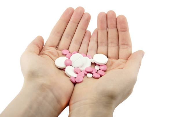 istock multicolored tablets of different size in hand top view close-up macro, isolated 1199747556
