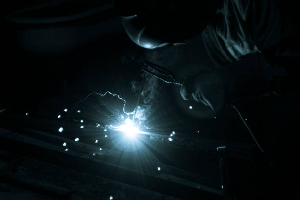 istock welder doing metal work at night, front and background blurred with bokeh effect 1199750920