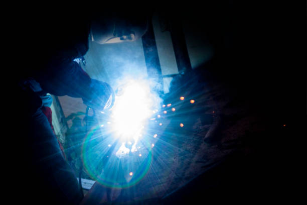 istock welder doing metal work at night, front and background blurred with bokeh effect 1199751022