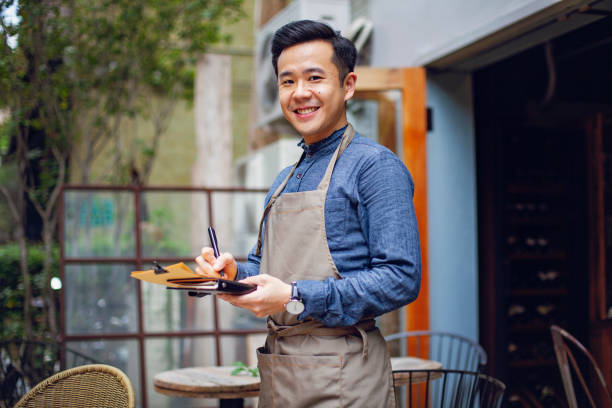 店の前に立つアジアの喫茶店のオーナー - small business restaurant asian ethnicity asia ストックフォトと画像