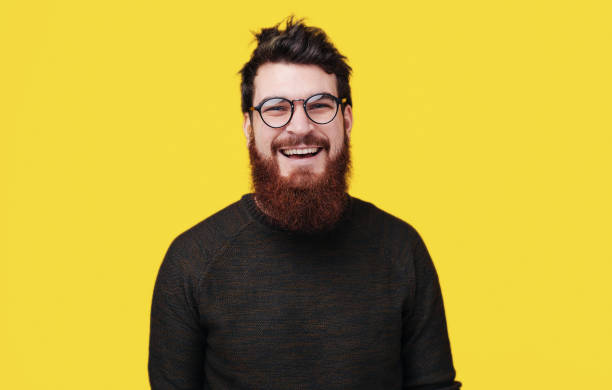 istock Handsome smiling bearded man standing over yellow background 1199754076