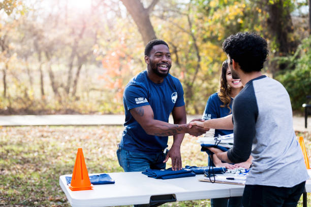 Mid adult man shakes hands with unrecognizable volunteer