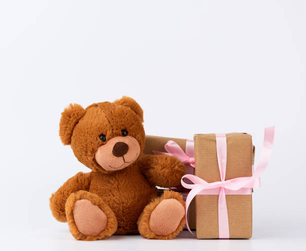 istock brown teddy bear, stack of gifts in boxes wrapped in brown paper 1199757592