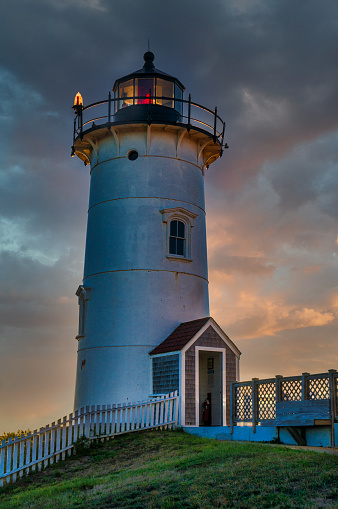The tower of Nobsca Lighthouse in Woods Hole, Massachusetts is backlit by the setting sun.
