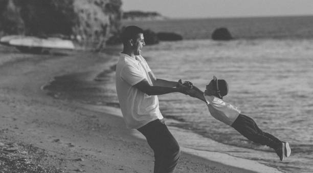 istock Young father playing with his son on the beach 1199767943