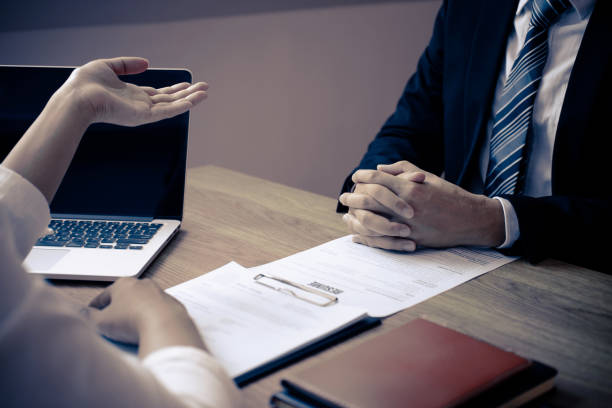 istock Employer or recruiter holding reading a resume with talking during about his profile of candidate, employer in suit is conducting a job interview, manager resource employment and recruitment concept 1199777511