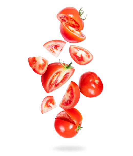 istock Whole and sliced fresh tomatoes fall down on a white background 1199778657