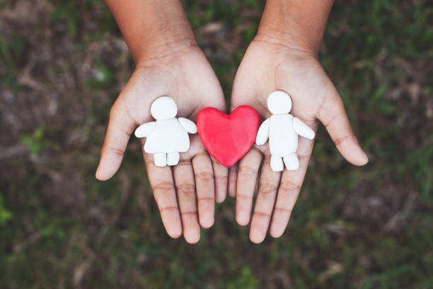 pareja de arcilla plástica con el corazón en la mano del niño. amante feliz y concepto de san valentín. - childs play clay small men team fotografías e imágenes de stock