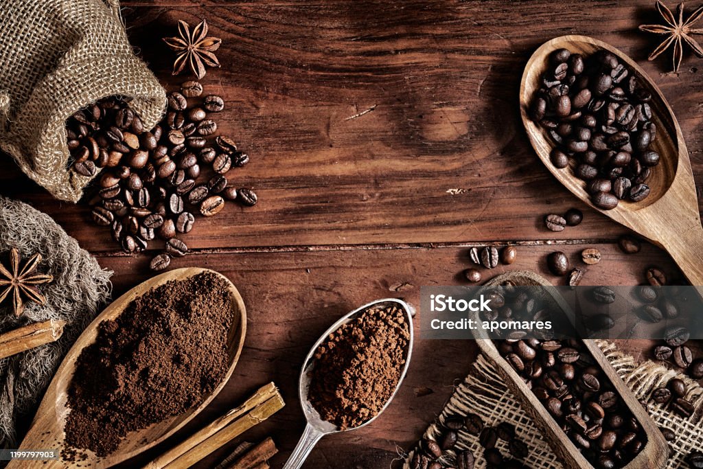 Hintergrund von Kaffeebohnen und gemahlenem Kaffee auf einem rustikalen Tisch - Lizenzfrei Kaffee - Getränk Stock-Foto