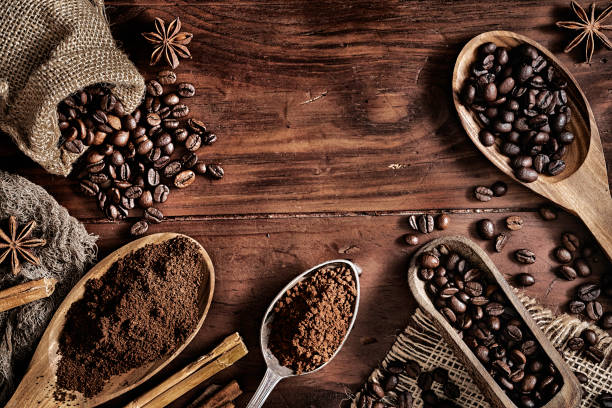 background of coffee beans and grinded coffee on a rustic table - burlap sack fotos imagens e fotografias de stock