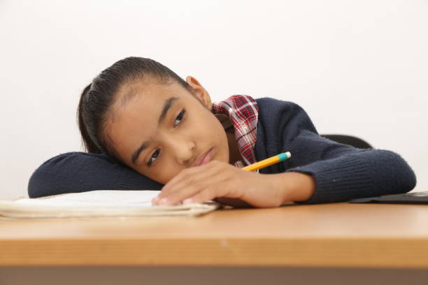 istock school age girl doing homework pensive bored imagining 1199800247