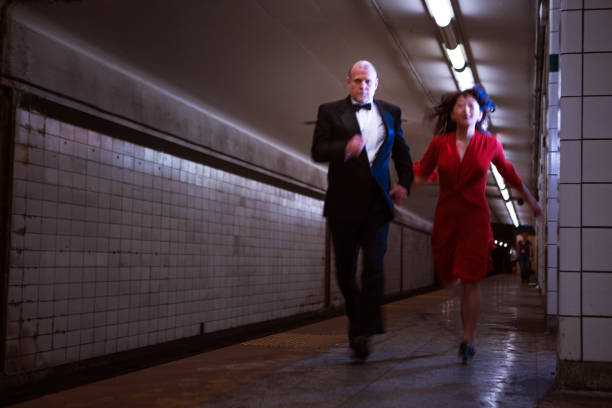 istock Elegant couple running on subway station 1199800670