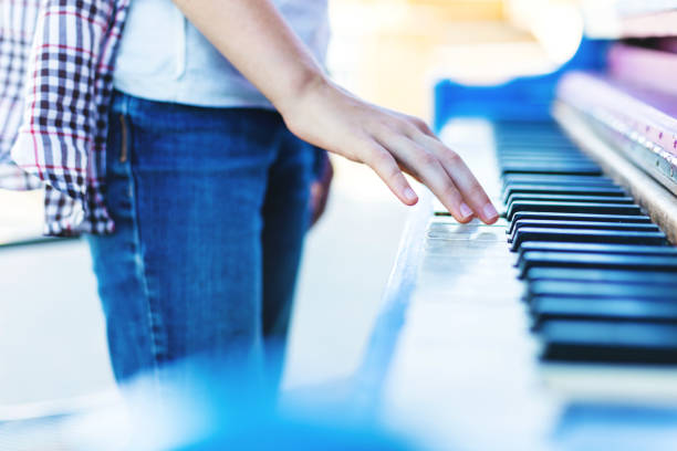 Happy Young Adolescent Generation Z Adolescent Blond Girl Outdoors Playing a Piano (Shot with Canon 5DS 50.6mp photos professionally retouched - Lightroom / Photoshop - original size 5792 x 8688 downsampled as needed for clarity and select focus used for dramatic effect)