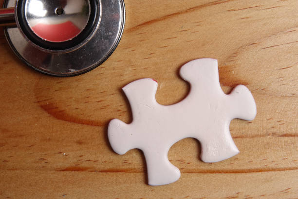 istock HEALTH CARE CONCEPT: Missing jigsaw puzzle and stethoscope on wooden table. Copy Space 1199805822