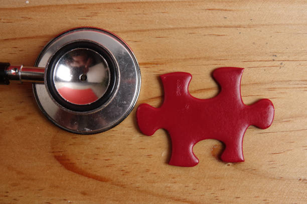 istock HEALTH CARE CONCEPT: Missing jigsaw puzzle and stethoscope on wooden table. Copy Space 1199805825