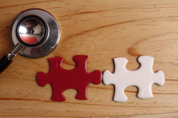 istock HEALTH CARE CONCEPT: Missing jigsaw puzzle and stethoscope on wooden table. Copy Space 1199805857
