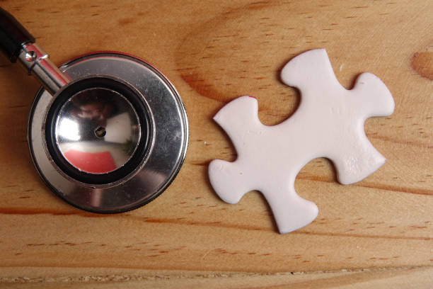 istock HEALTH CARE CONCEPT: Missing jigsaw puzzle and stethoscope on wooden table. Copy Space 1199805881