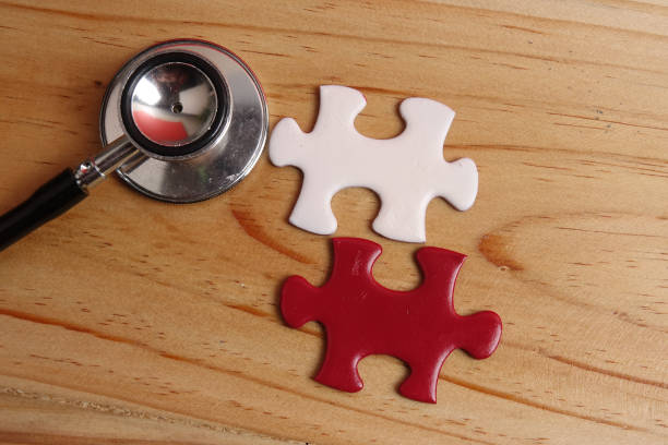 istock HEALTH CARE CONCEPT: Missing jigsaw puzzle and stethoscope on wooden table. Copy Space 1199805890