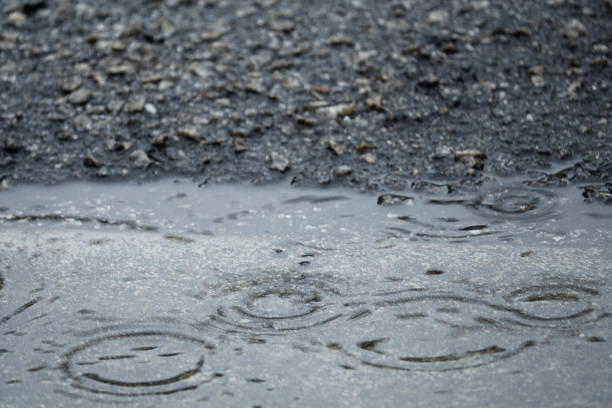 istock Rain on asphalt or tarmac road creating ripples, Blurred,high contrast and selective focus image. 1199806414