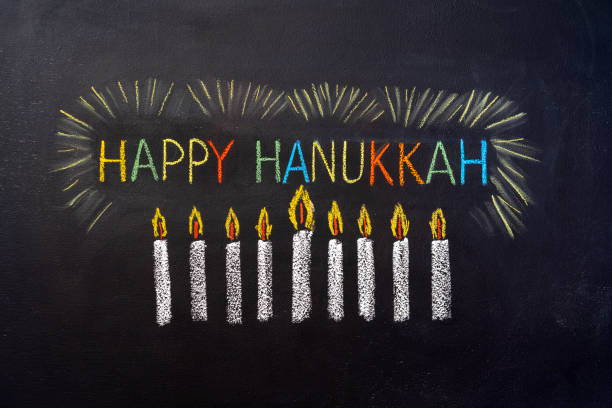 nine candles and inscription Happy Hanukkah painted on a chalkboard stock photo