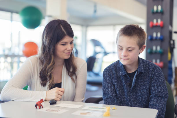istock Speech therapist works with a young boy 1199808549