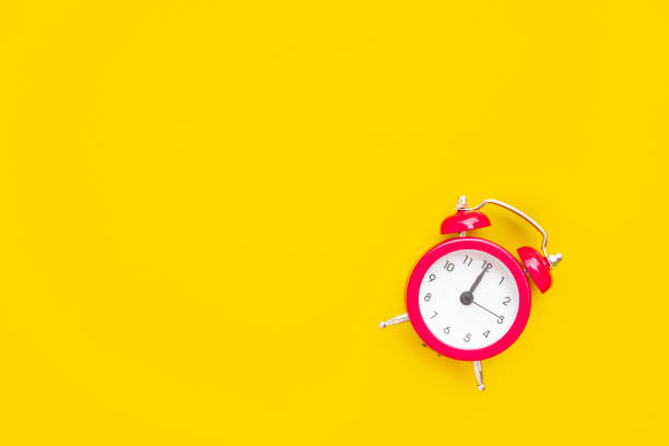 istock Abstract creative flat lay vintage yellow table top view office background concept red clock on paper color in minimal style, Hot summer holiday time to break workplace at noon for lunch, Retro Hipster back to school vacation 1199811947