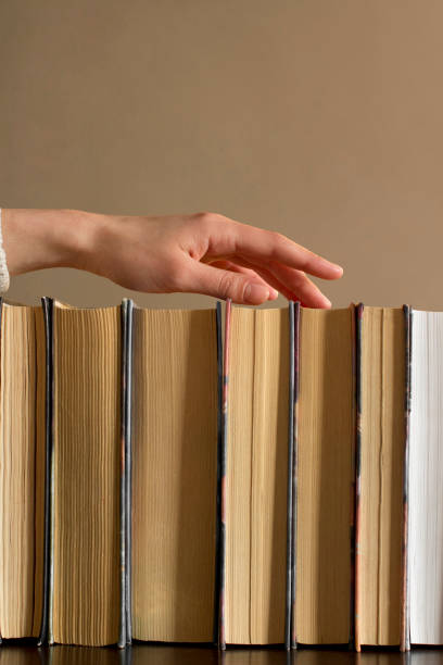 istock young woman choosing a book from a bookshelf 1199813028