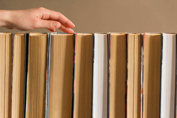 istock young woman choosing a book from a bookshelf 1199813040