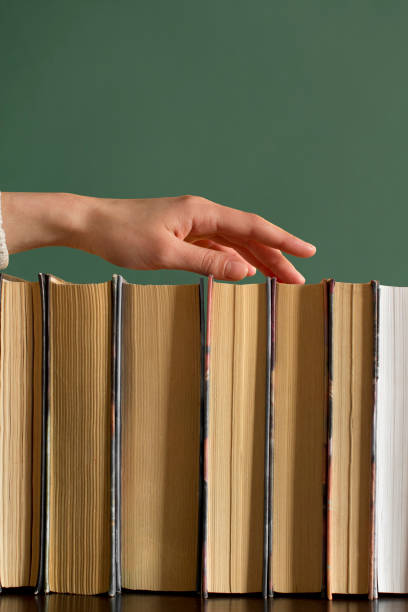 istock young woman choosing a book from a bookshelf 1199813046