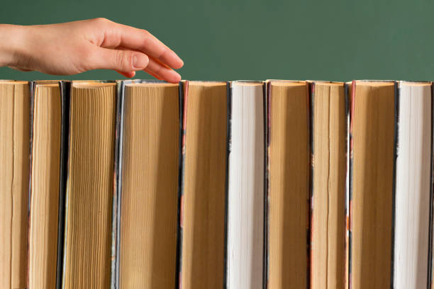 istock young woman choosing a book from a bookshelf 1199813057