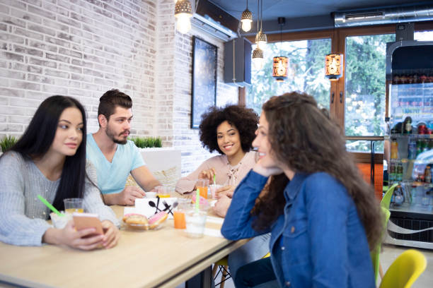 istock Friends sitting in restaurant and talking 1199813123