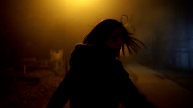 a terrified woman runs away from a maniac through the cemetery at night