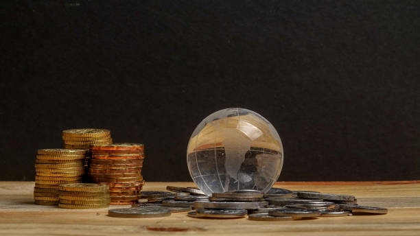istock SAVING CONCEPT. Stack of coins on the wooden table over black background. 1199814791