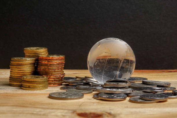 istock SAVING CONCEPT. Stack of coins on the wooden table over black background. 1199814839