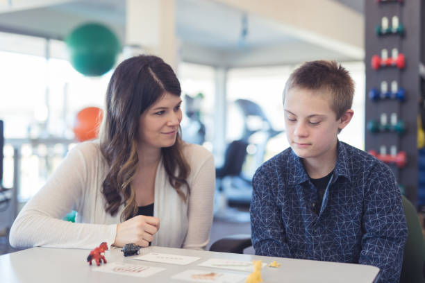 istock Speech therapist works with a young boy 1199815687