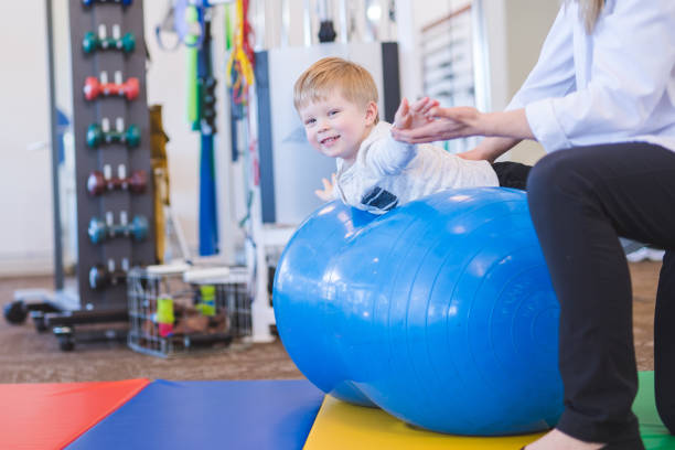 istock Young boy working with a physical therapist at a clinic 1199815696