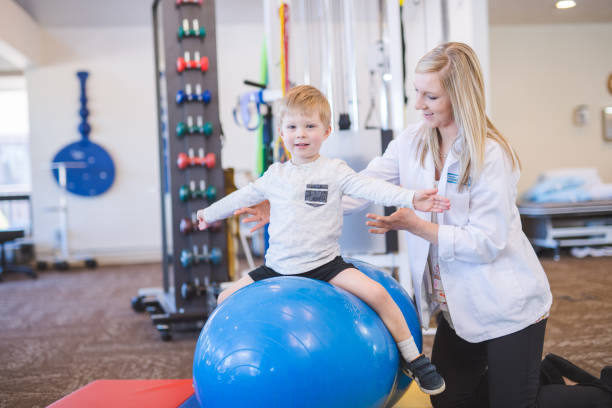 istock Physical therapist working with a young boy in the clinic 1199815717