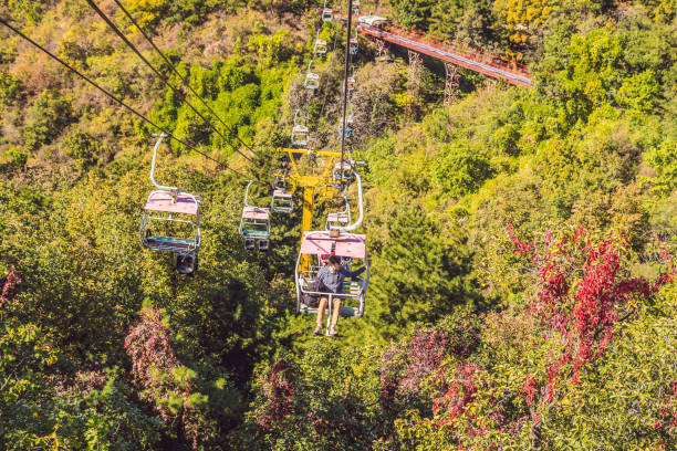 ein mann fährt mit der seilbahn zur chinesischen mauer - mutianyu stock-fotos und bilder