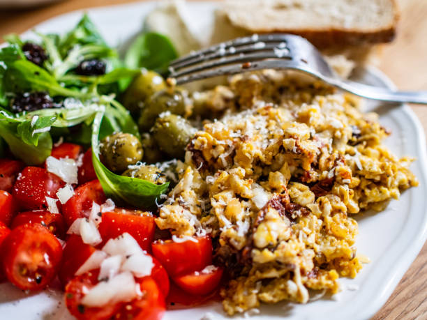 istock Scrambled eggs with toasts and vegetables on wooden table 1199816243