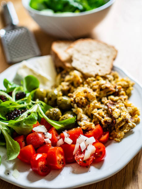 istock Scrambled eggs with toasts and vegetables on wooden table 1199816317
