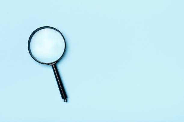 istock Closeup glass magnifier on a blue background copy space for text 1199817577