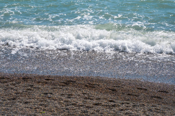 istock Sea water with foam on a pebble beach. 1199817598