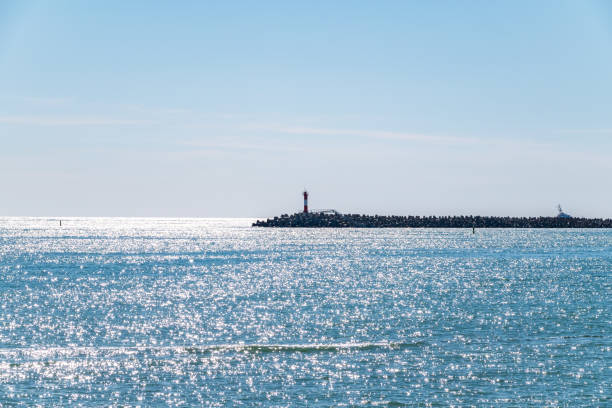 istock Clear sky over the sea with a breakwater and a lighthouse 1199817667