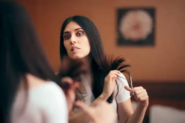 Photo of Woman Looking in Mirror Cutting Split Hair Ends