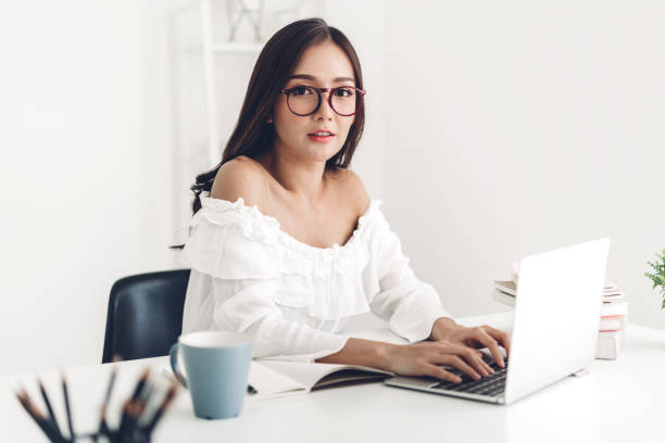 istock Girl student sitting and studying and learning online with laptop computer and reading a book before the exam at home.education concept 1199820652
