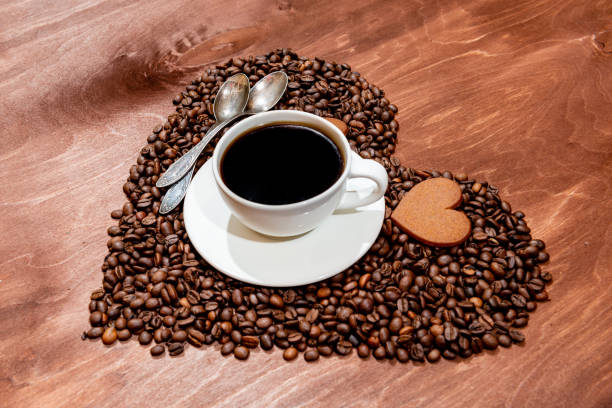 istock White coffee mug, heart shaped gingerbread and two spoons on a heart shaped base made from coffee beans 1199825321